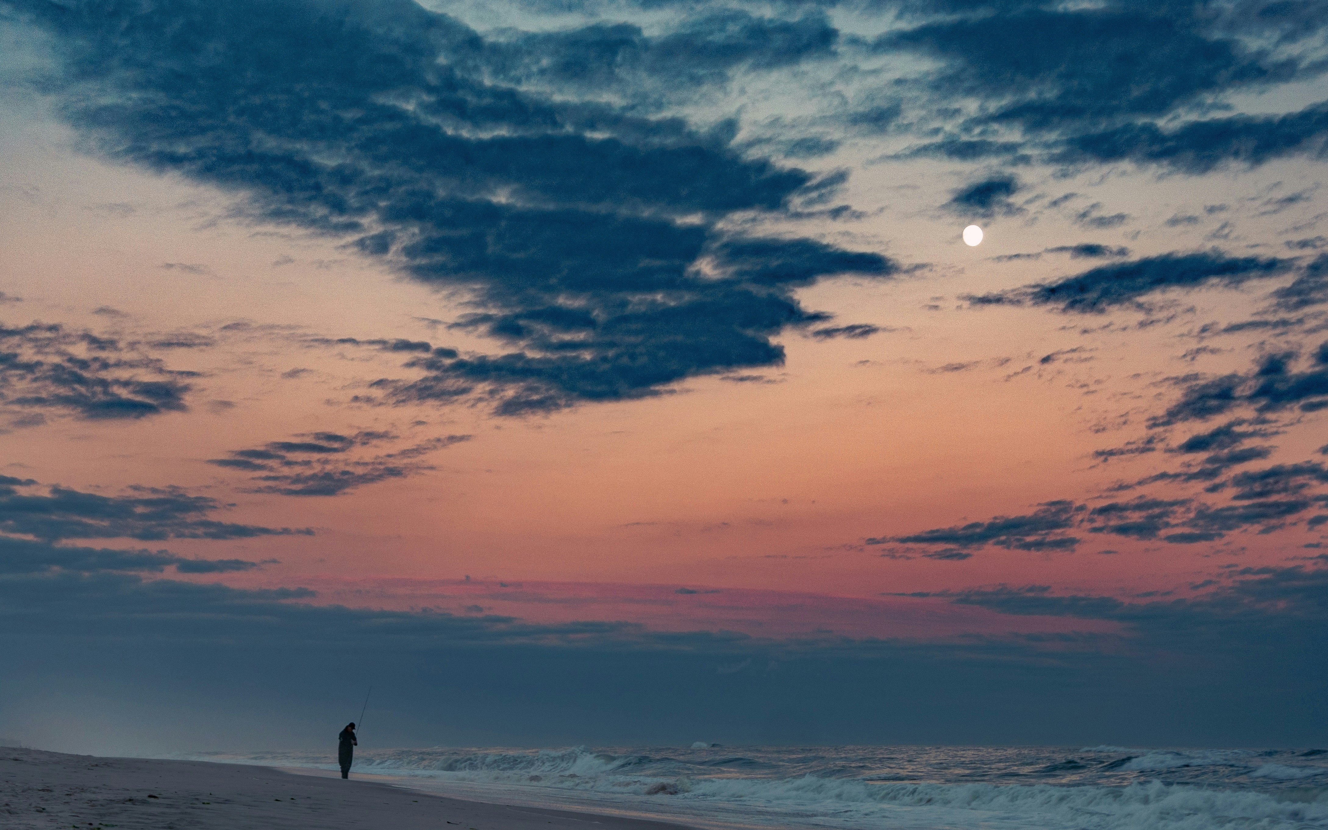 silhouette of person standing on beach during sunset